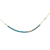 Necklace with blue beads and gold clasp on a white background