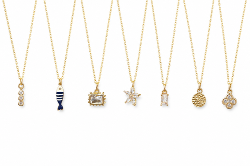 Seven build-your-own charm necklaces on gold-filled chains, shown on white