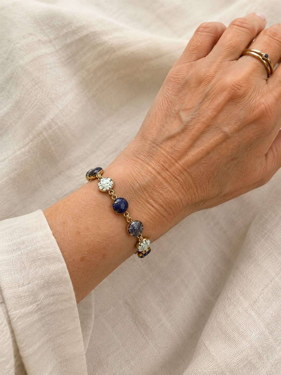Blue crushed gemstone bracelet worn on the wrist, lapis lazuli, sodalite, and larimar in gold filled links, handmade by June & Simple