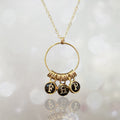 Personalized letter charm necklace with three initials on a gold-filled chain, soft light background
