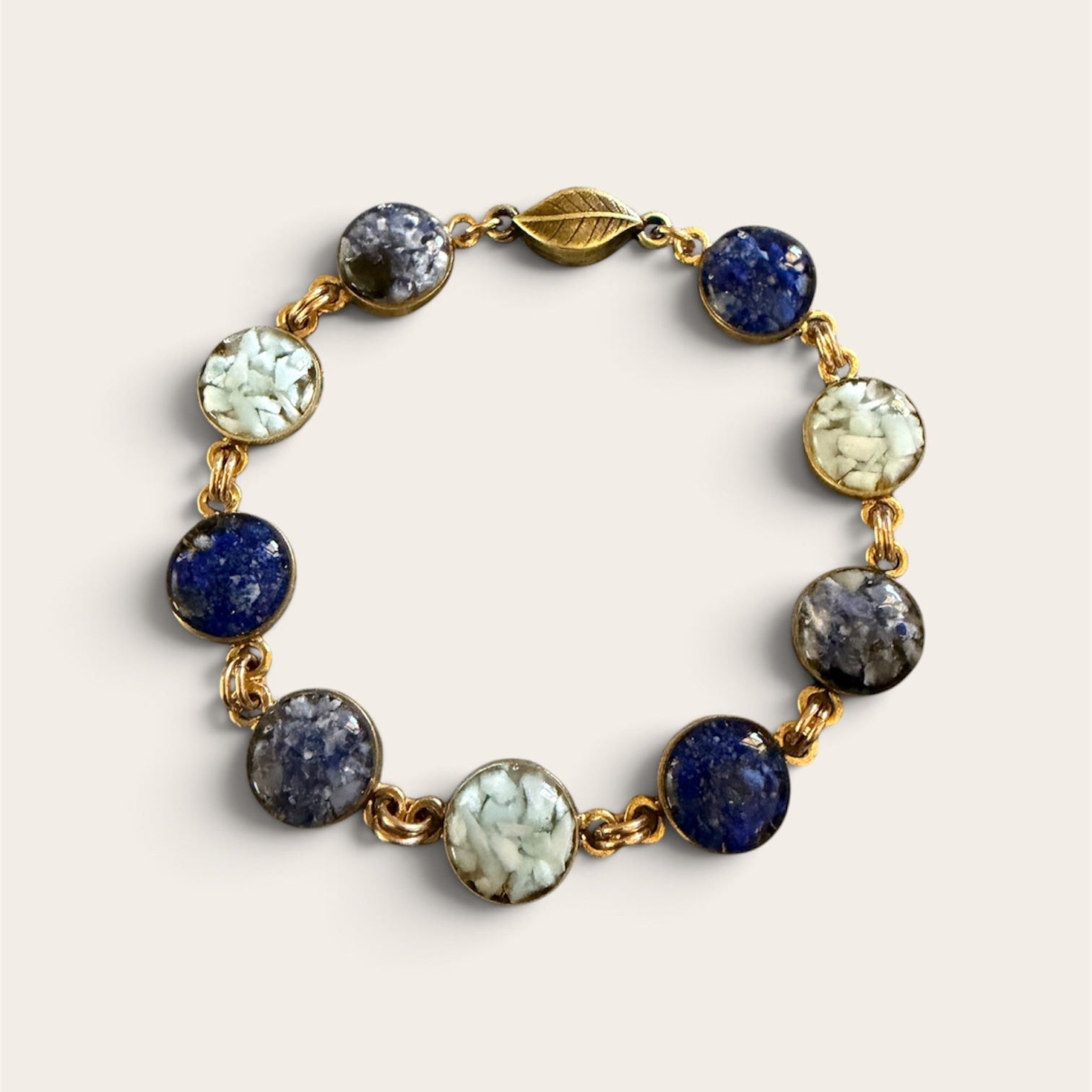 Blue crushed gemstone bracelet with lapis lazuli, sodalite, and larimar set in resin in gold filled links with a magnetic clasp, handmade by June & Simple