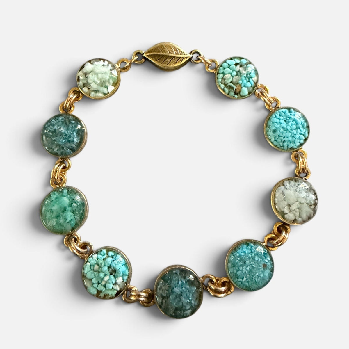 Turquoise crushed gemstone bracelet with nine circles of turquoise, amazonite, and blue apatite set in resin in gold filled links with a magnetic leaf clasp, handmade by June & Simple