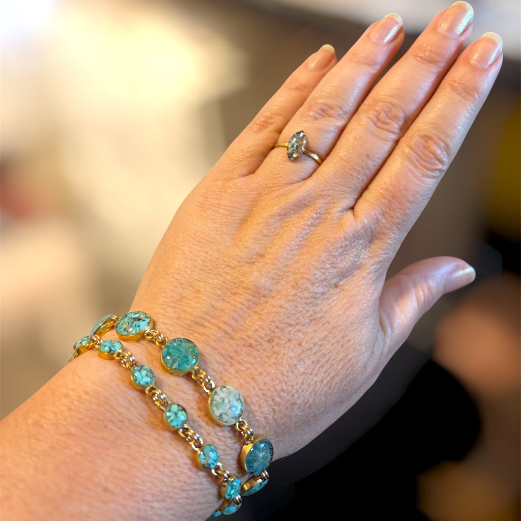 Two turquoise crushed gemstone bracelets stacked on the wrist, the larger circle and the smaller circle versions, in gold filled links, handmade by June & Simple